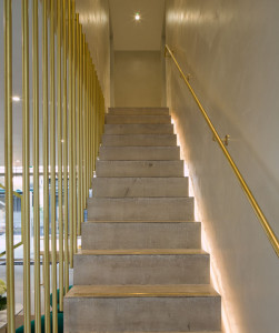 Polished concrete stairs and walls combined with brass finishings at the flagship store of Monica Vinader in Chelsea